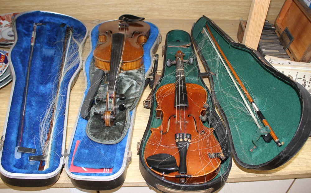 A violin with two piece back and bow, and a childs violin with bow, both with cases